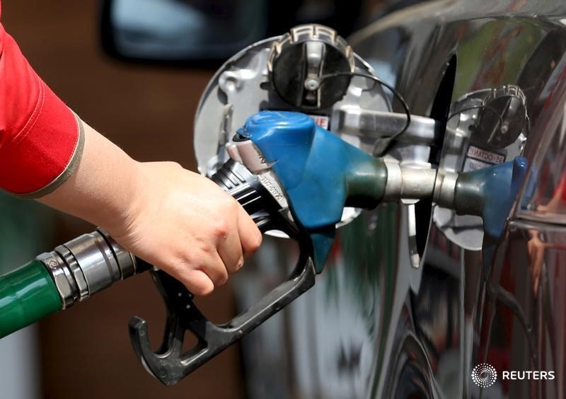 © Reuters. A female employee fills the tank of a car at a petrol station in Cairo