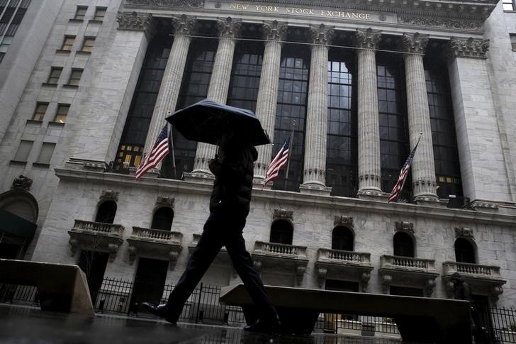 © Reuters. A man passes by the New York Stock Exchange during a rain storm in New York
