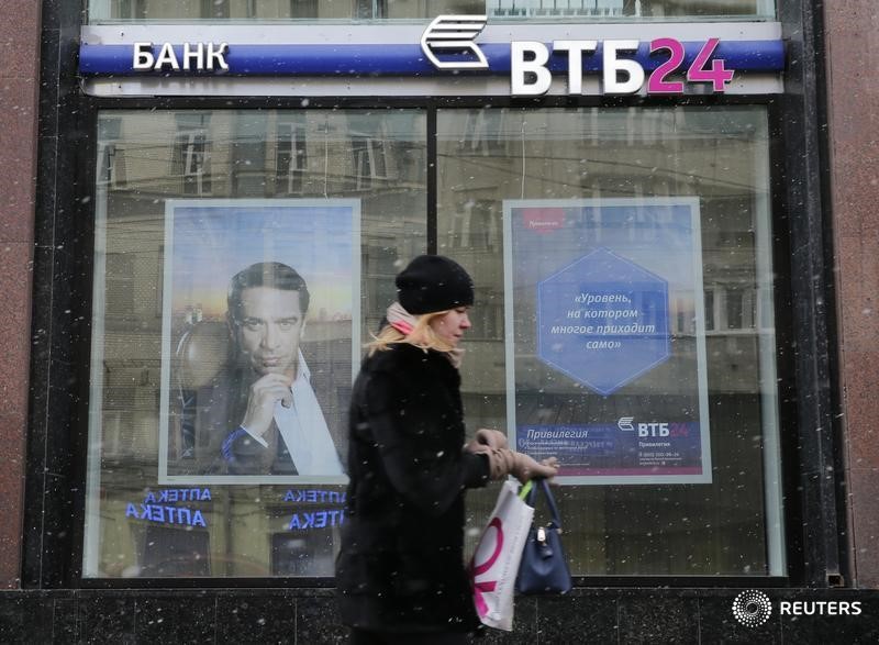 © Reuters. Женщина проходит мимо отделения ВТБ 24 в Москве