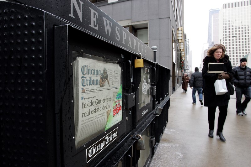 © Reuters. People walk past a newspaper box in Chicago