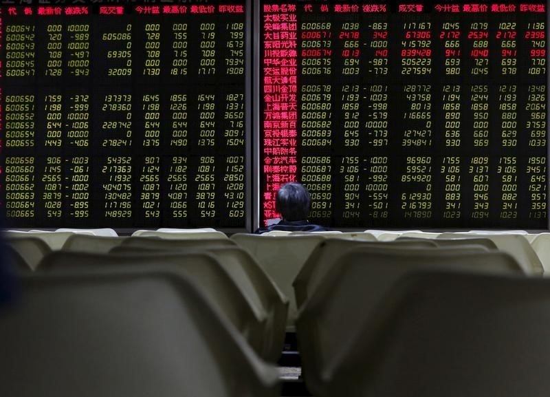 © Reuters. An investor looks at an electronic board showing stock information at a brokerage house in Beijing