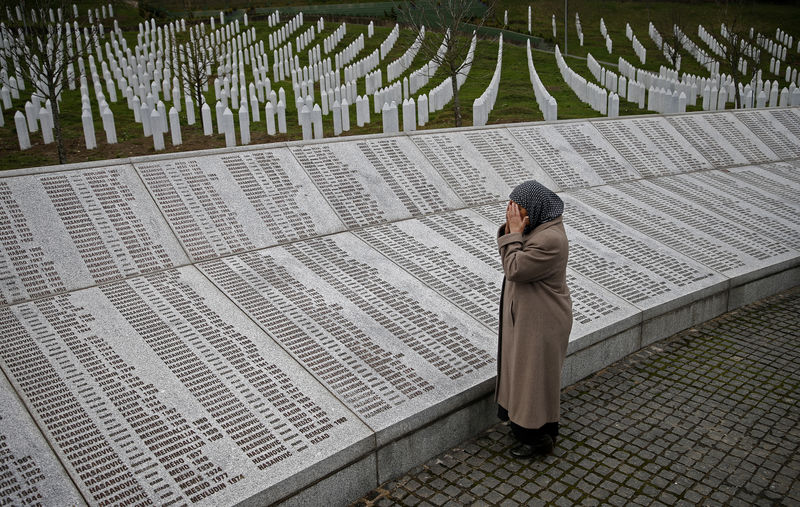 © Reuters. Bida Smajlovic, prays near the Memorial plaque with names of killed in Srebrenica massacre before watching the Trial in Hague Tribunal, in Potocari near Srebrenica