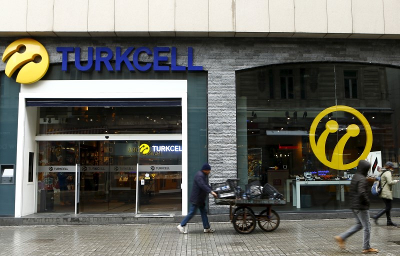 © Reuters. Pedestrians walk past by the main Turkcell shop in central Istanbul
