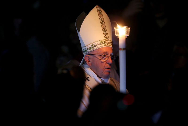 © Reuters. El Papa Francisco sostiene un cirio mientras lidera la Vigilia Pascual en la Basílica San Pedro en el Vaticano