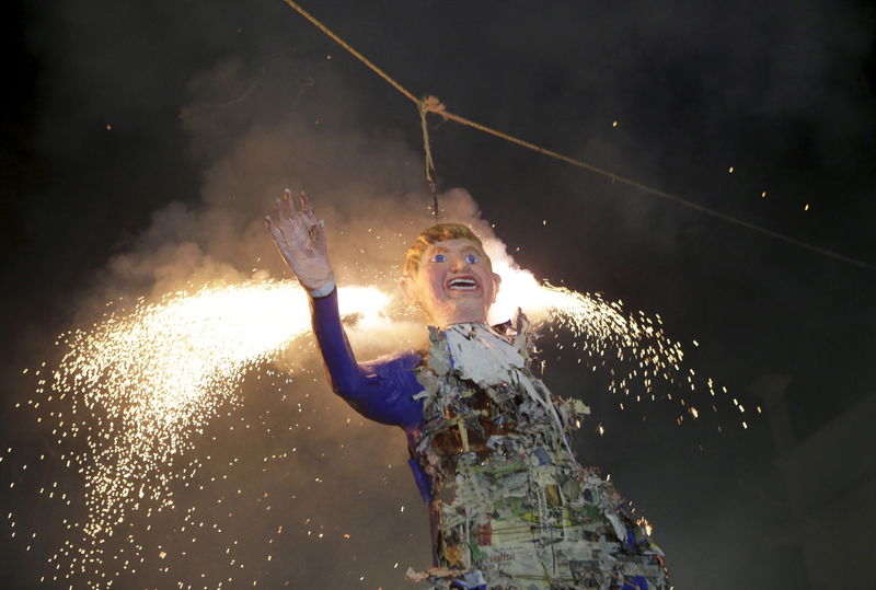 © Reuters. مكسيكيون يحرقون دمى لترامب خلال احتفال ديني