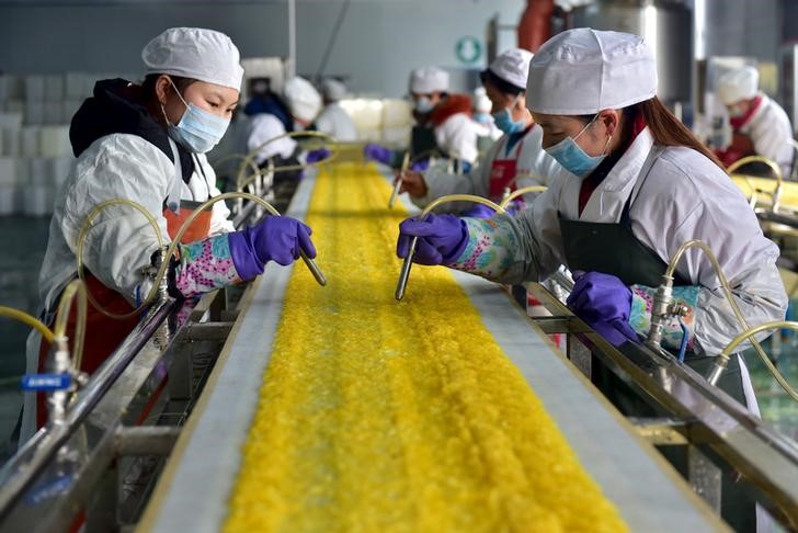 © Reuters. Employees work at a food processing factory in Yichang