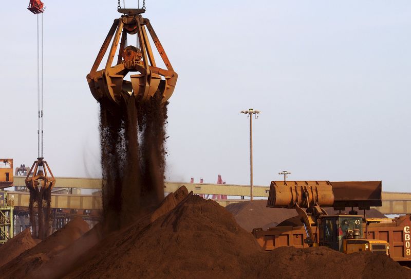 © Reuters. File picture of cranes unloading imported iron ore from a ship at a port in Rizhao