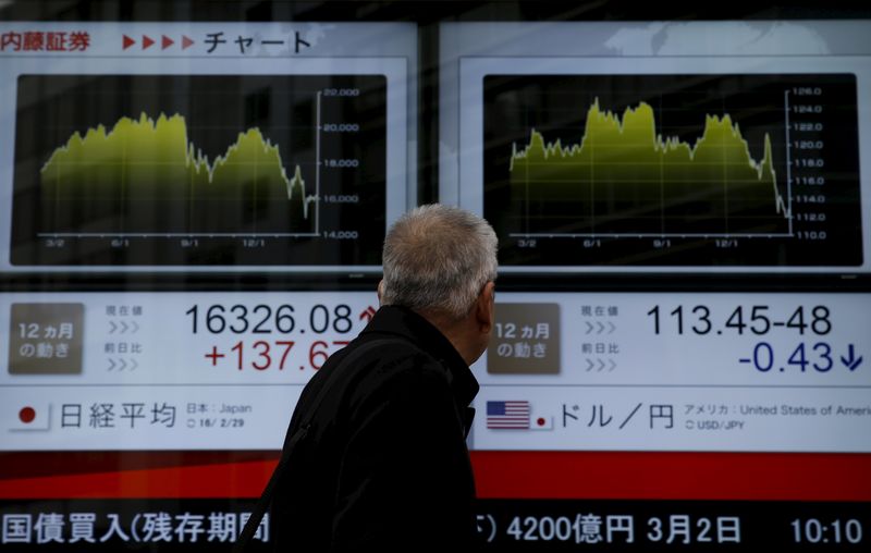 © Reuters. A man looks at an electronic board outside a brokerage in Tokyo