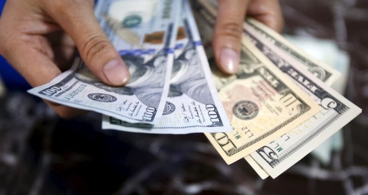 © Reuters. An employee checks U.S. dollar bank-notes at a bank in Hanoi, Vietnam