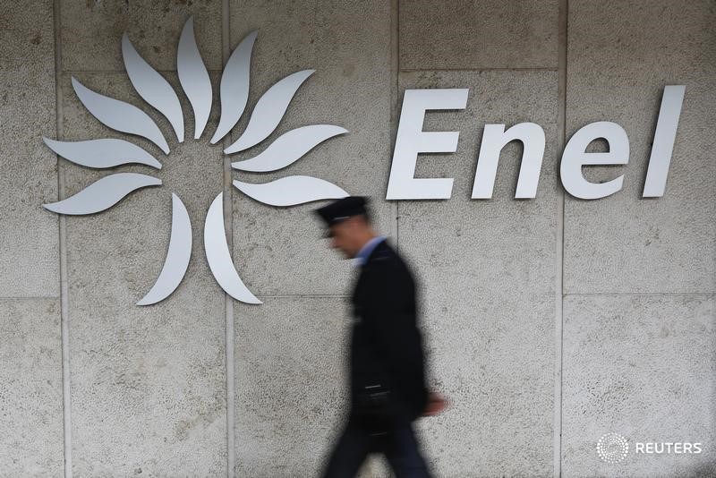 © Reuters. Охранник проходит мимо логотипа Enel у штаб-квартиры компании в Риме
