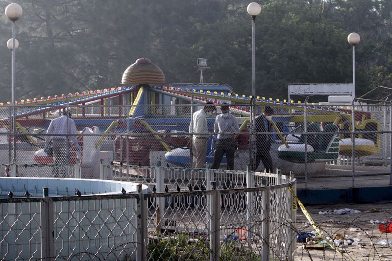 © Reuters. Forensic officers look for evidence at the site of a blast that happened outside a public park on Sunday, in Lahore