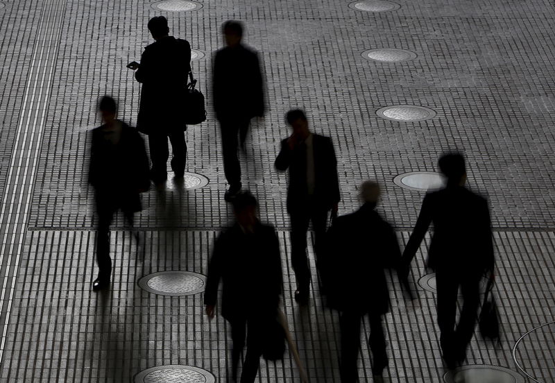 © Reuters. People walk at an office building at a business district in Tokyo