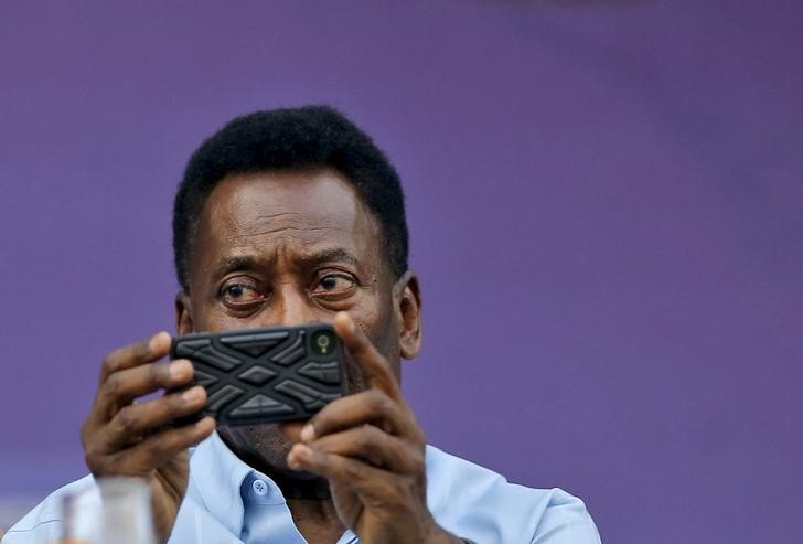 © Reuters. Pelé tira foto com telefone celular durante evento cultural em Nova Délhi