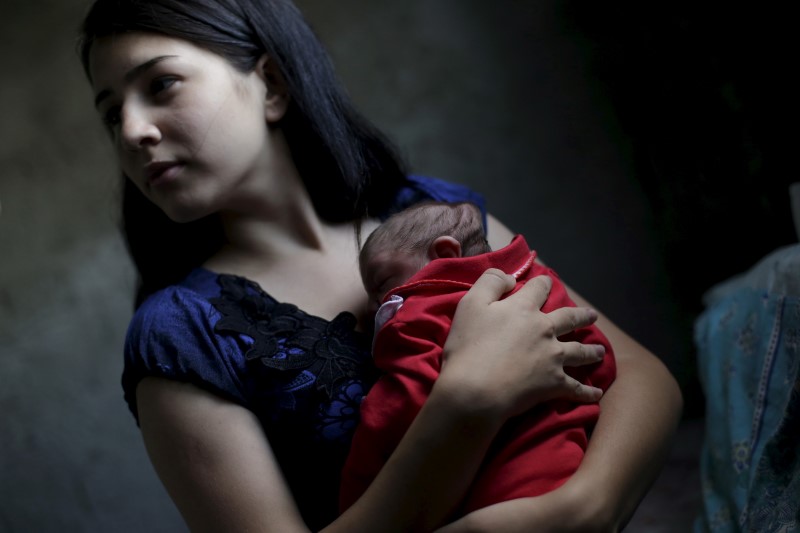 © Reuters. Ianka Mikaelle Barbosa, 18 anos, posa com sua segunda filha, Sophia, que nasceu com microcefalia