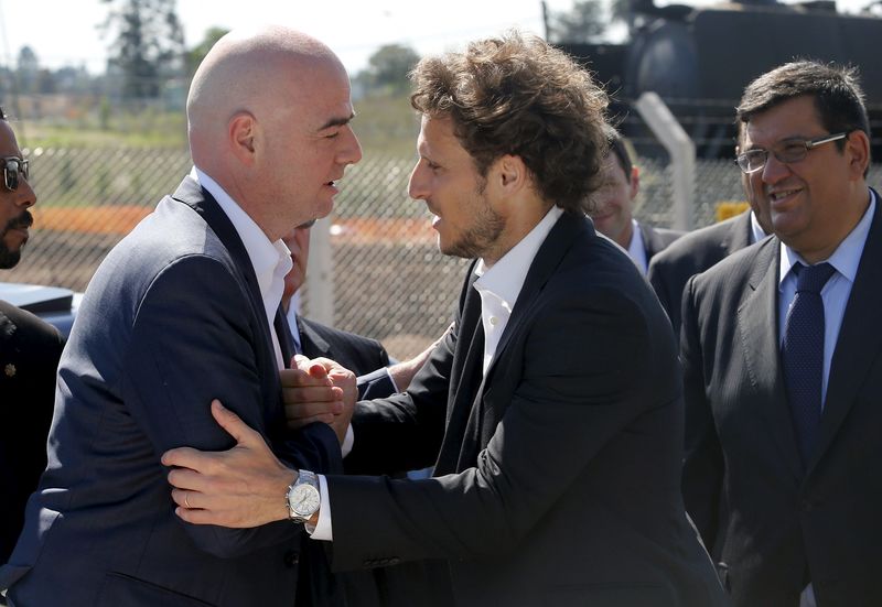 © Reuters. Fifa's President Gianni Infantino and Uruguayan soccer player Diego Forlan shake hands in Montevideo