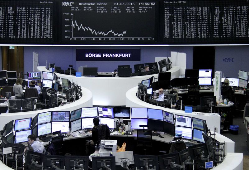 © Reuters. Traders work at their desks in front of the German share price index, DAX board, at the stock exchange in Frankfurt