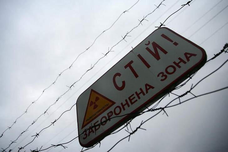 © Reuters. Предупреждающий об опасности радиации знак на ограде зоны отчуждения под Чернобылем