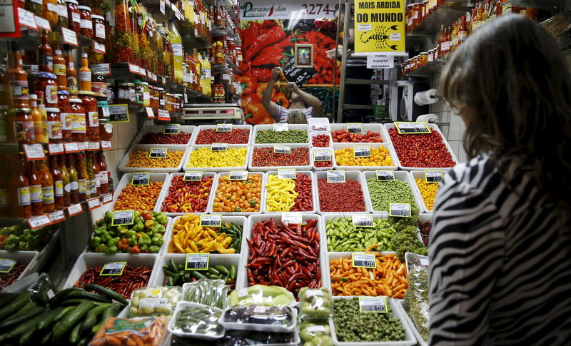 © Reuters. File photo of a woman looking at chillies and peppers at a market in Belo Horizonte