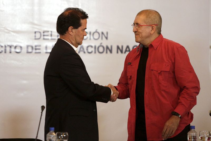 © Reuters. Frank Pearl, head of Colombian government delegation and Antonio Garcia, head of National Liberation Army delegation, shake hands after signing a joint statement to begin formal peace talks at Venezuela's foreign Ministry in Caracas