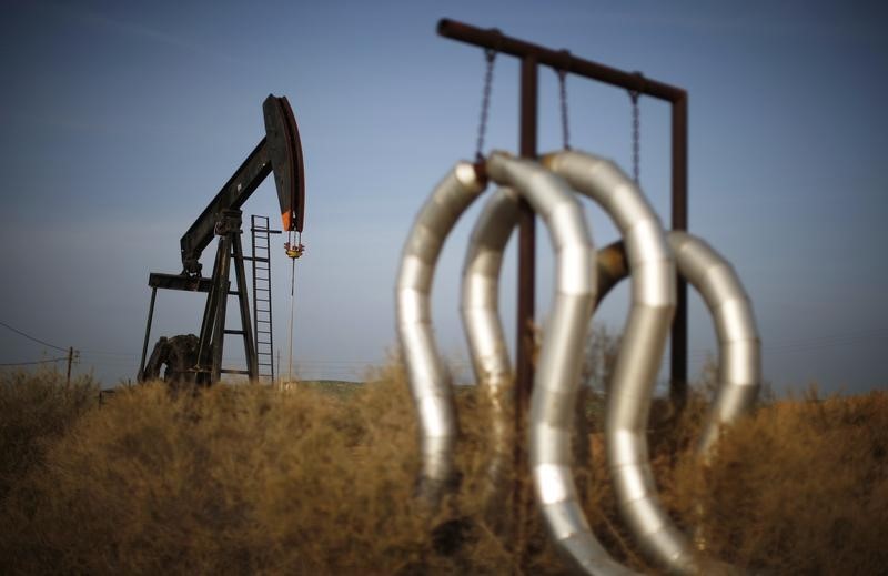 © Reuters. Pump jack and pipes are seen on an oil field near Bakersfield on a foggy day, California