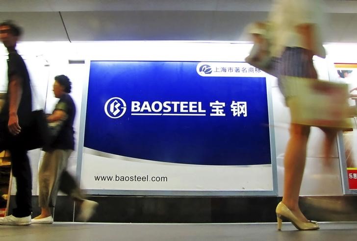 © Reuters. People walk past an advertising board of Baosteel Group in Shanghai