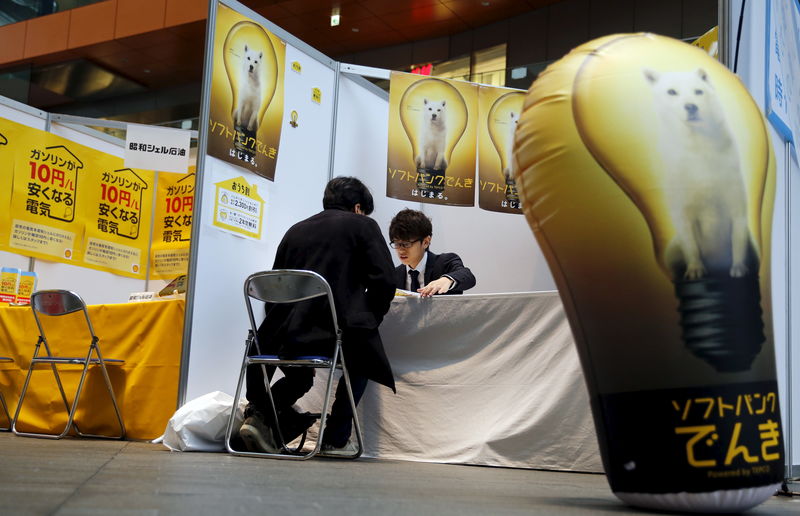 © Reuters. A visitor gets a briefing at a Softbank booth at an event to promote the understanding of general consumers about electric power liberalisation in Tokyo, Japan