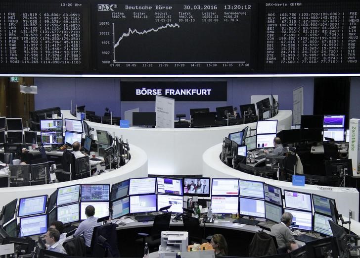 © Reuters. Traders work at their desks in front of the German share price index, DAX board, at the stock exchange in Frankfurt