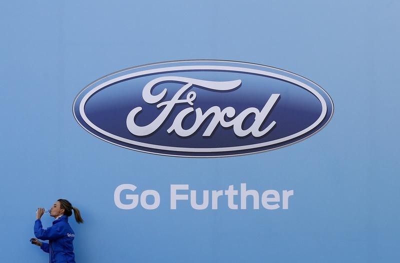 © Reuters. Woman walks past a logo of carmaker Ford at the entrance to a media event for the launch of a concept car in Sydney