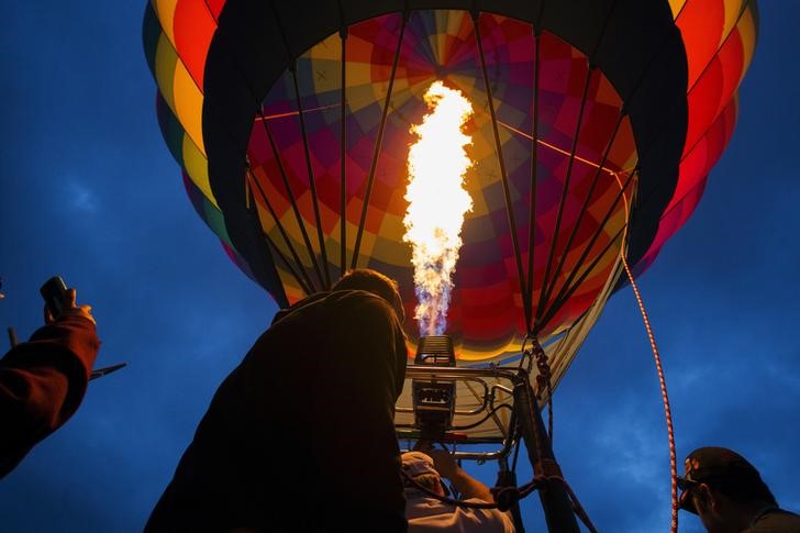 © Reuters. Attendees watch a hot air balloon gets lit by flames as it is being prepared for take off during the 2015 Albuquerque International Balloon Fiesta in Albuquerque