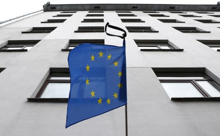 © Reuters. European Union flag with black ribbons hangs in commemoration of the victims of today's Brussels explosions outside the building of the Delegation of the European Union in Minsk