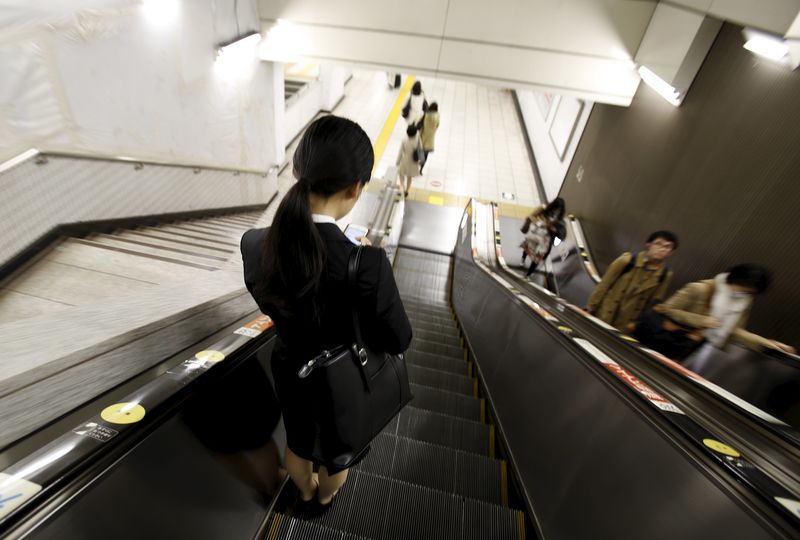 © Reuters. A student job seeker rides on an escalator inside a train station at a business district in Tokyo