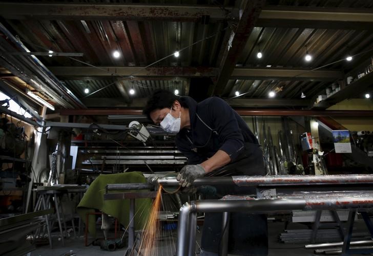 © Reuters. An engineer makes an arm rail for residential buildings inside a metal processing factory at an industrial zone in downtown Tokyo