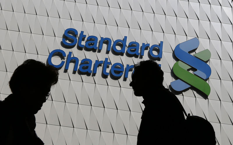 © Reuters. File photo of passersby walking in front of the main branch of Standard Chartered in Hong Kong