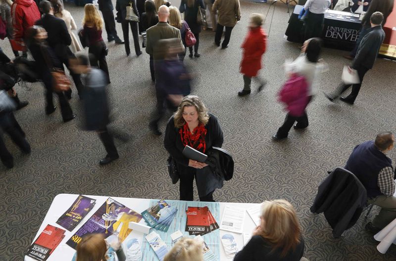 © Reuters. File photo of a job seeker talking to an exhibitor at the Colorado Hospital Association health care career fair in Denver