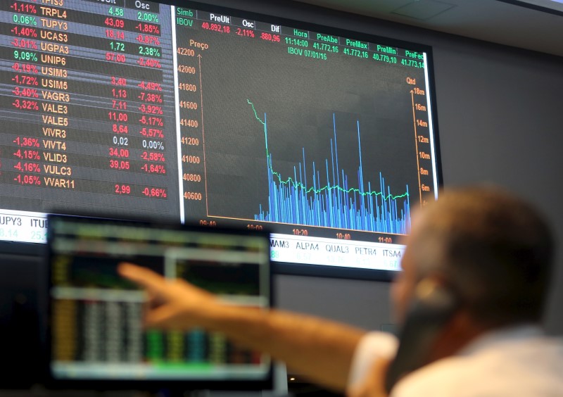 © Reuters. A man points to electronic board showing the graph of the recent fluctuations of market indices at the floor of Brazil's BM&F Bovespa Stock Market in Sao Paulo