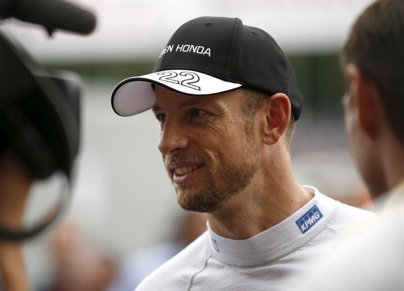 © Reuters. McLaren Formula One driver Jenson Button of Britain speaks to media at paddock area after the qualifying session of the Japanese F1 Grand Prix at the Suzuka Circuit in Suzuka, Japan