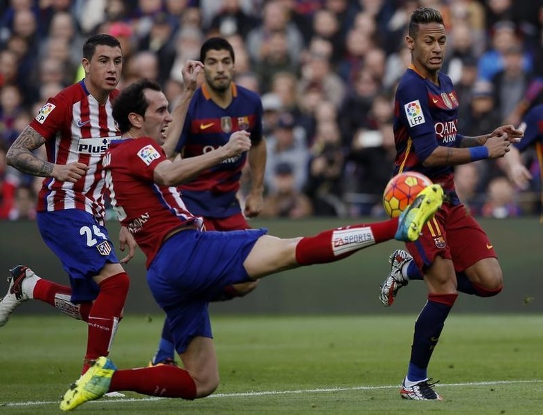 © Reuters. El jugador uruguayo del Atlético de Madrid Diego Godin (izqda) corta un avance de Neymar, del Barcelona, durante un encuentro de Liga disputado en el Camp Nou.