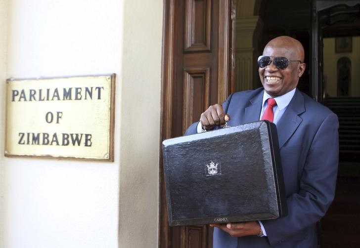 © Reuters. Zimbabwe's Finance Minister Patrick Chinamasa presents the briefcase carrying the 2016 National Budget in Harare