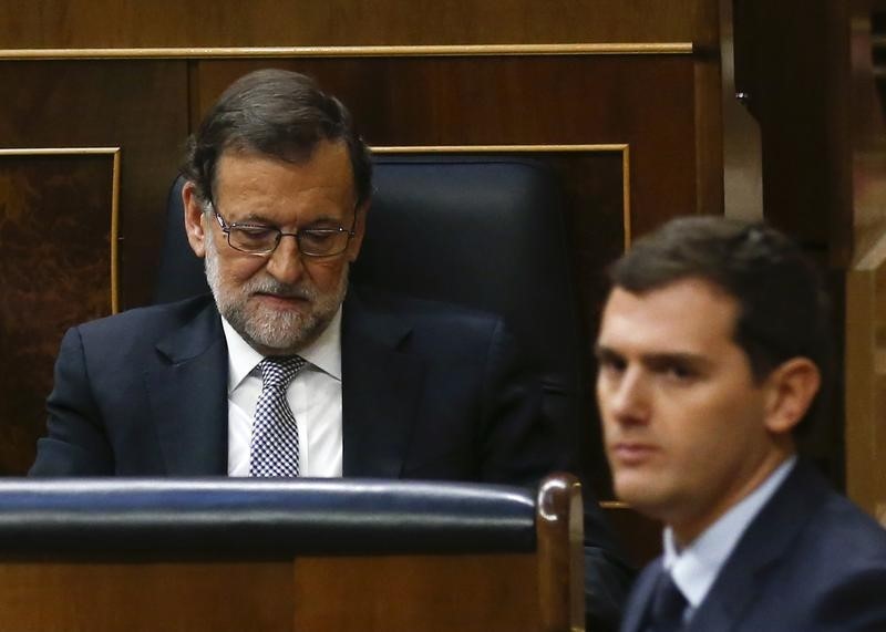 © Reuters. Ciudadanos party leader Albert Rivera walks past People's Party leader Mariano Rajoy during an investiture debate at parliament in Madrid