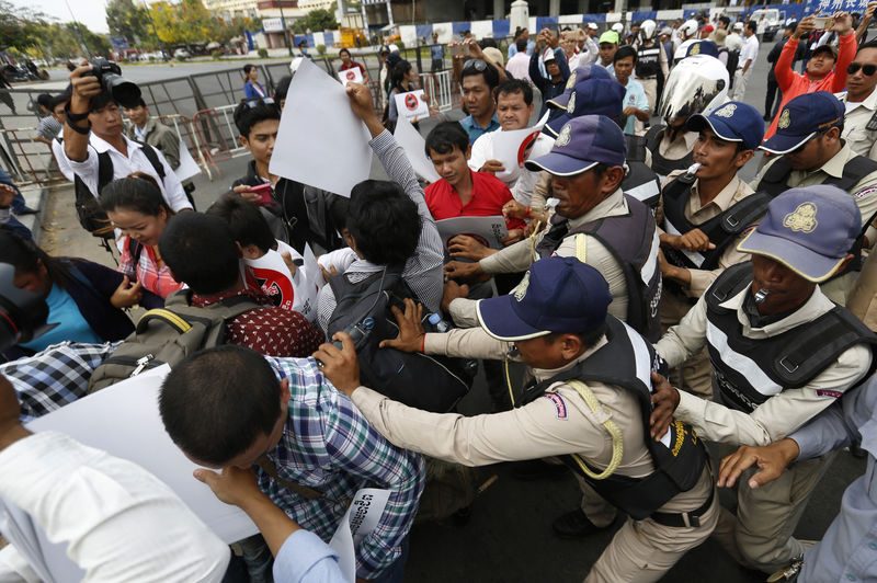 © Reuters. Cambodian security officers push back protesters to prevent them from reaching the National Assembly during a protest against trade union law in Phnom Penh
