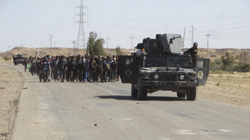 © Reuters. Iraqi security forces escort civilians who fled their homes due to the clashes between Iraqi security forces and Islamic state militants in the town of Hit in Anbar province