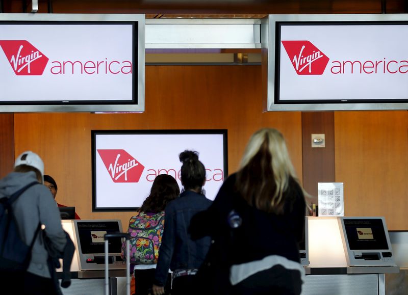 © Reuters. Passengers check in for their flights at the Virgin America ticket counter in San Diego, California