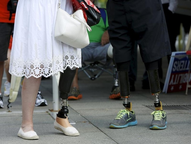 © Reuters. A man and a woman chat during a protest held by the Amputee Coalition and the American Orthotic & Prosthetic Association in front of the Department of Health and Human Services in Washington