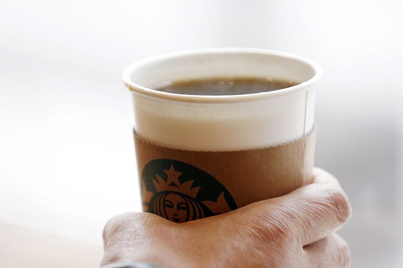 © Reuters. A man holds an Americano at a Starbucks coffee shop in Seoul