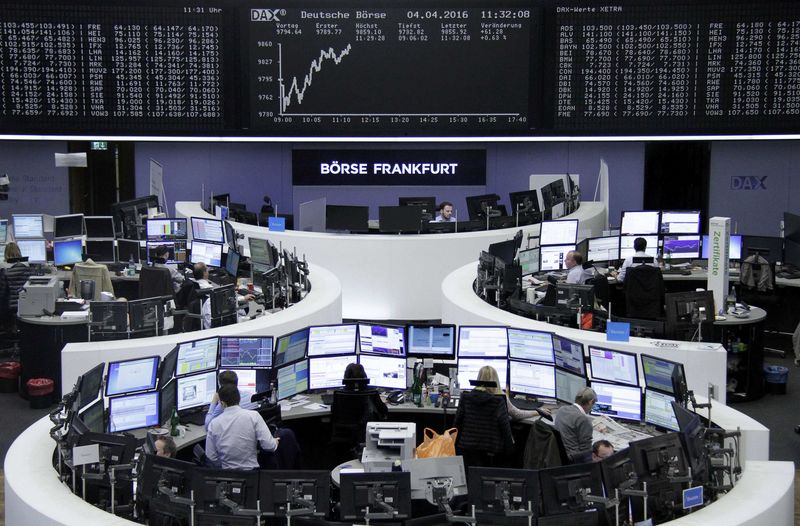 © Reuters. Traders work at their desks in front of DAX board at Frankfurt stock exchange
