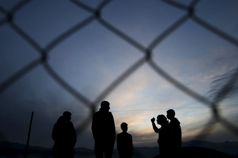 © Reuters. Migrants who are waiting to cross the Greek-Macedonian border, chat at a makeshift camp near the village of Idomeni