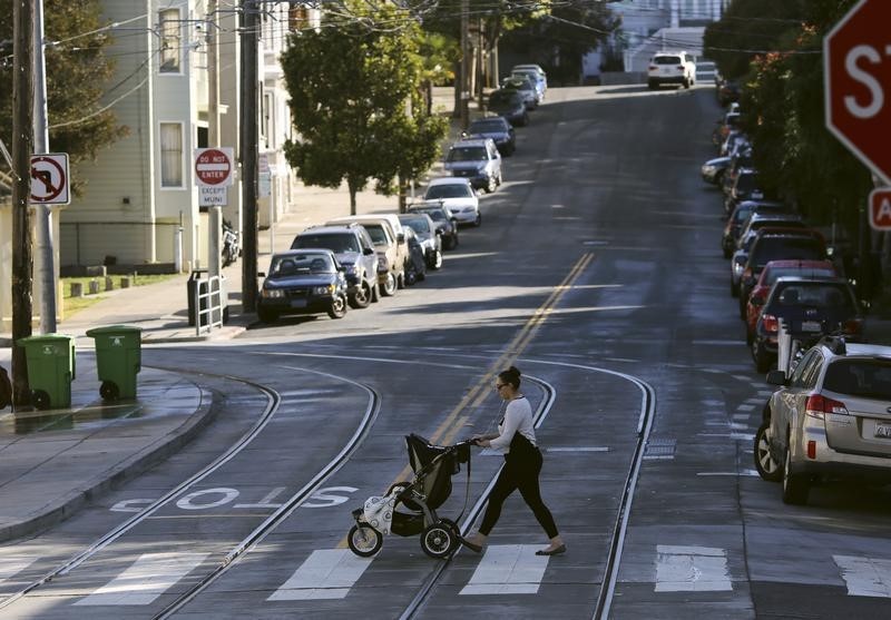 © Reuters. A woman walks with a child stroller across a pedestrian crossing, in San Francisco