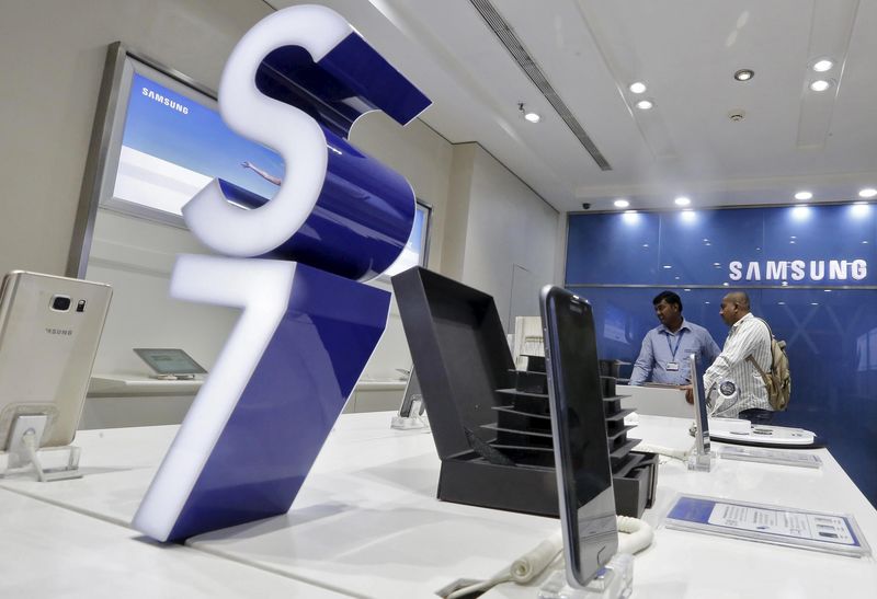 © Reuters. A salesperson serves a customer (R) at a Samsung mobile store inside a shopping mall in New Delhi