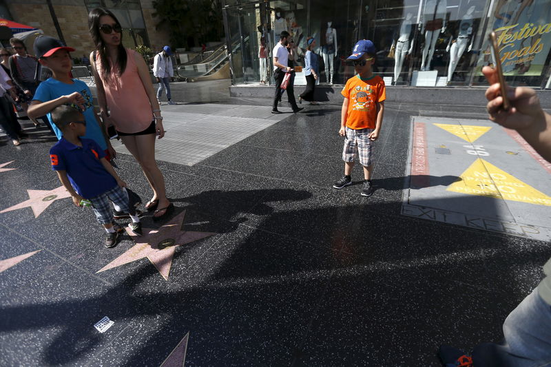 © Reuters. Tourists pose on the star of U.S. Republican presidential candidate Donald Trump on the Hollywood Walk of Fame in Hollywood