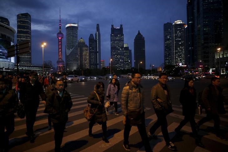 © Reuters. People cross a road after work in the financial district of Pudong in Shanghai